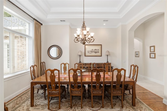 dining room with a wealth of natural light, hardwood / wood-style floors, and crown molding