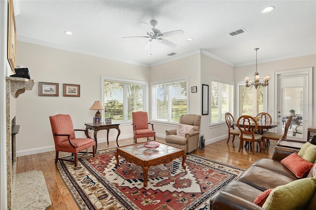 living room with a textured ceiling, ceiling fan with notable chandelier, hardwood / wood-style flooring, and crown molding