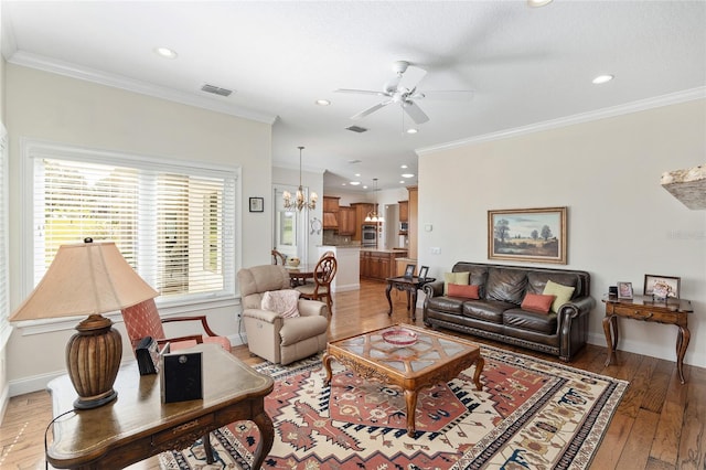 living room with light hardwood / wood-style floors, ceiling fan with notable chandelier, and crown molding