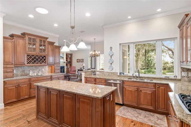 kitchen featuring backsplash, stainless steel dishwasher, light hardwood / wood-style flooring, a kitchen island, and pendant lighting