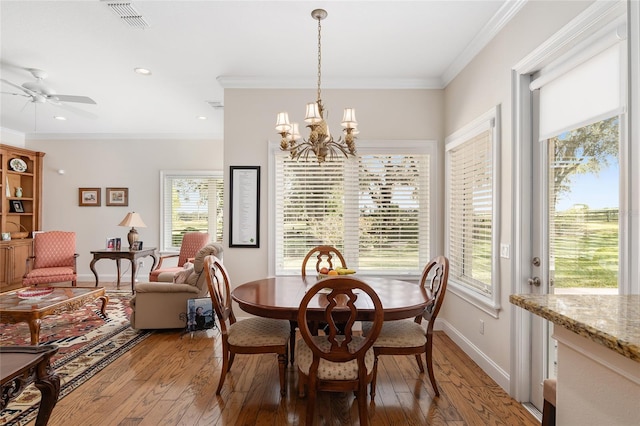 dining space with light hardwood / wood-style floors, ceiling fan with notable chandelier, and crown molding