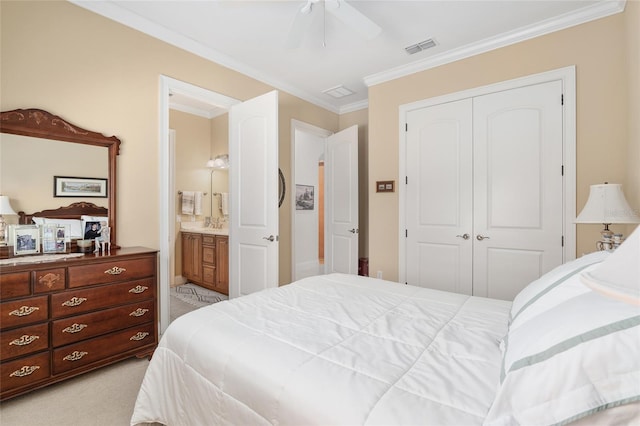 carpeted bedroom with a closet, ensuite bath, ceiling fan, and crown molding