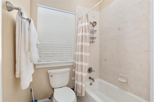 bathroom with shower / bath combo with shower curtain and toilet