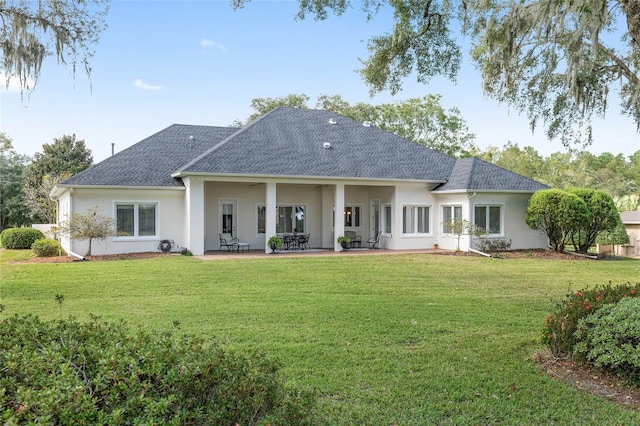 back of property with a lawn and a patio area