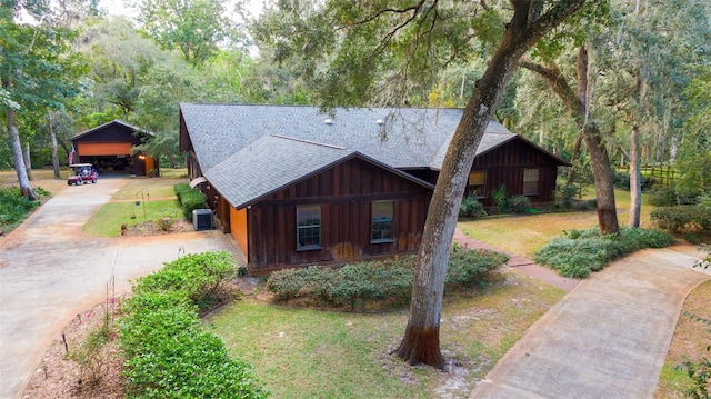 view of front of home featuring central air condition unit, a garage, and a front yard