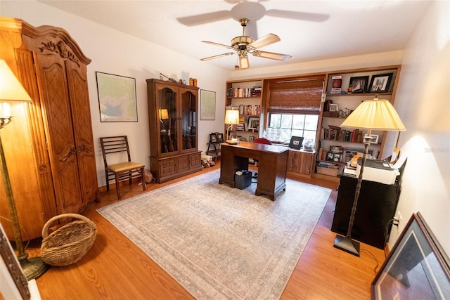 office with light hardwood / wood-style floors and ceiling fan