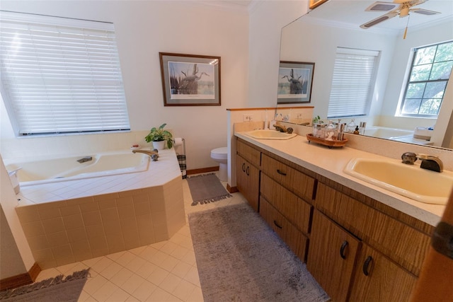 bathroom featuring tile patterned floors, crown molding, tiled tub, vanity, and toilet