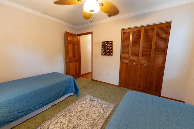 carpeted bedroom featuring ceiling fan, a closet, and crown molding