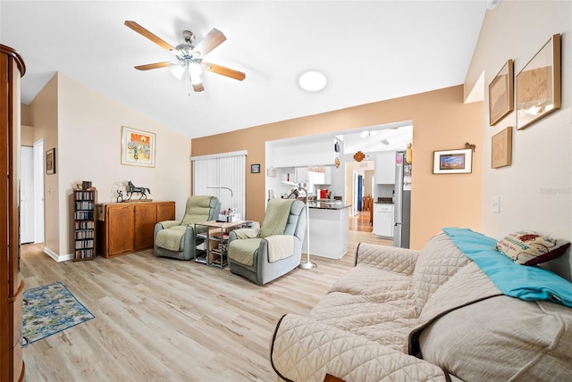 living room featuring light hardwood / wood-style flooring, ceiling fan, and vaulted ceiling