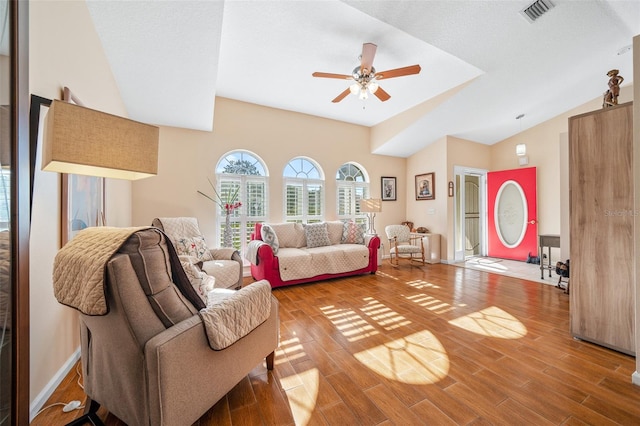 living room with hardwood / wood-style floors, ceiling fan, a textured ceiling, and vaulted ceiling