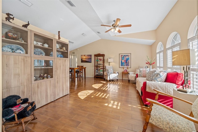 living room featuring lofted ceiling, ceiling fan, and wood-type flooring