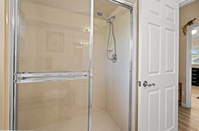 bathroom featuring wood-type flooring and an enclosed shower