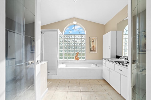 bathroom with tile patterned flooring, vanity, separate shower and tub, and vaulted ceiling