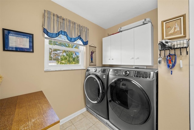 washroom featuring cabinets, light tile patterned flooring, and separate washer and dryer