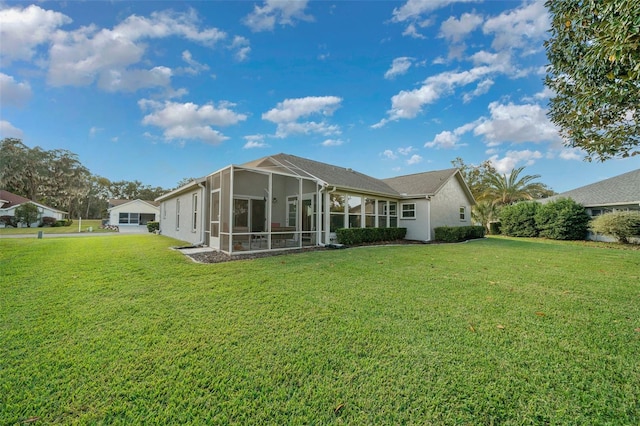 back of property featuring a sunroom and a yard