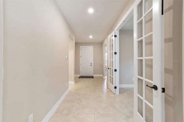 corridor featuring light tile patterned floors and french doors