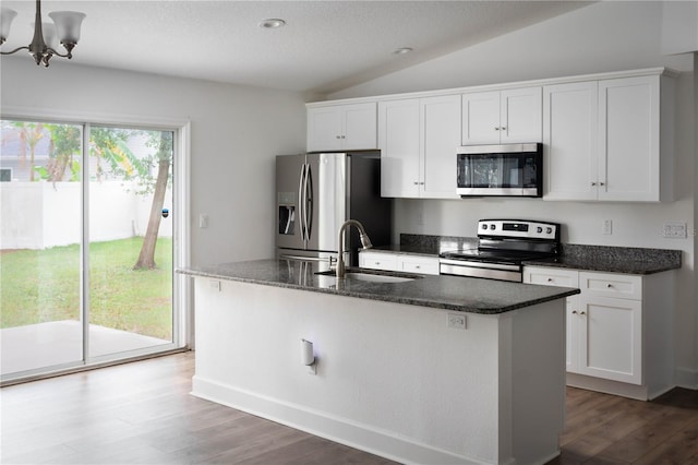 kitchen with stainless steel appliances, a kitchen island with sink, sink, white cabinets, and lofted ceiling