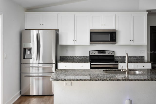 kitchen with white cabinets, lofted ceiling, sink, and appliances with stainless steel finishes