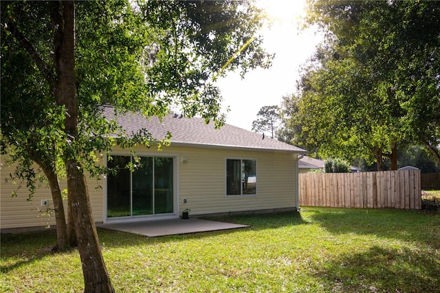 back of house featuring a lawn and a patio area