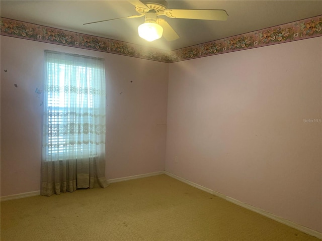 carpeted spare room with ceiling fan