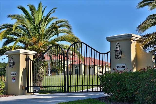 view of gate with a lawn