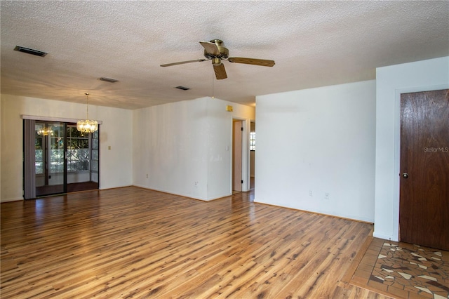 unfurnished room featuring ceiling fan with notable chandelier, hardwood / wood-style floors, and a textured ceiling