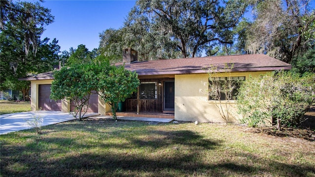 view of front of property featuring a porch, a garage, and a front yard