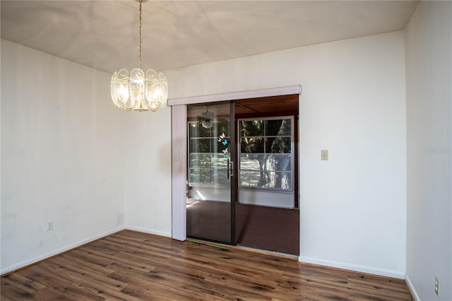 unfurnished dining area with dark wood-type flooring and an inviting chandelier