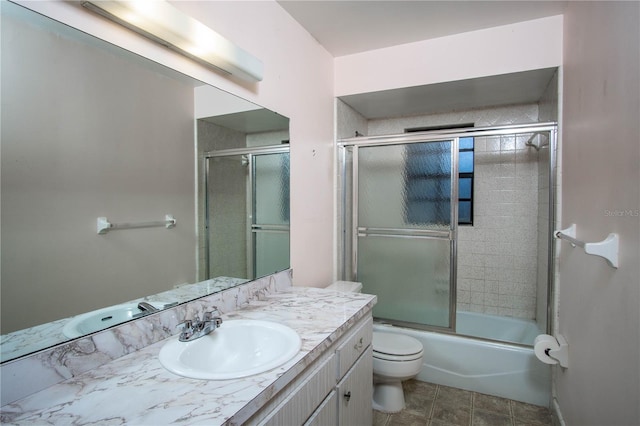 full bathroom featuring shower / bath combination with glass door, vanity, and toilet