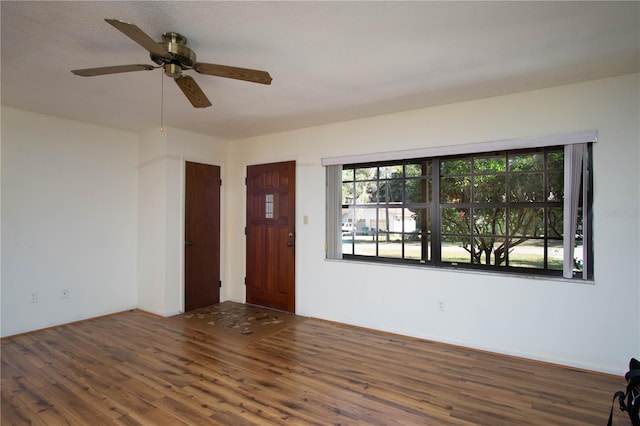 empty room featuring ceiling fan and dark hardwood / wood-style flooring