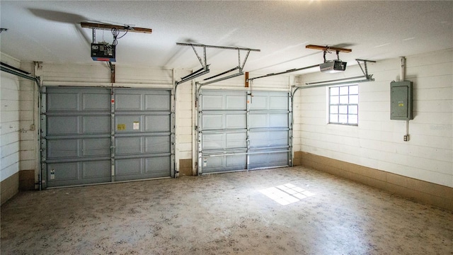 garage with a garage door opener and electric panel