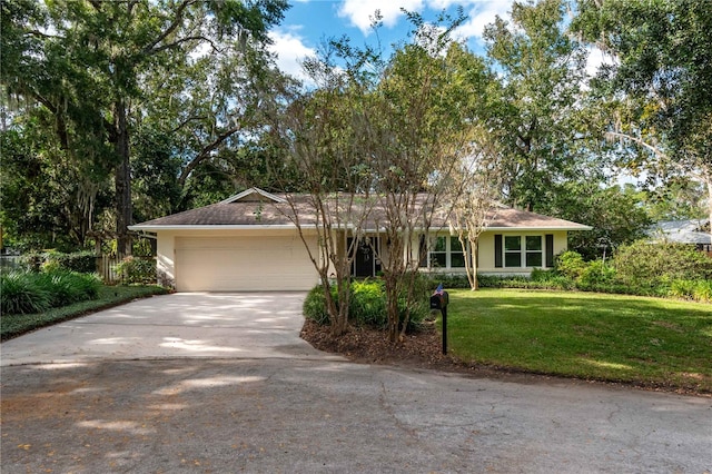 ranch-style house featuring a garage and a front yard