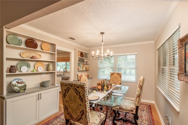 dining area with hardwood / wood-style flooring, plenty of natural light, ornamental molding, and sink