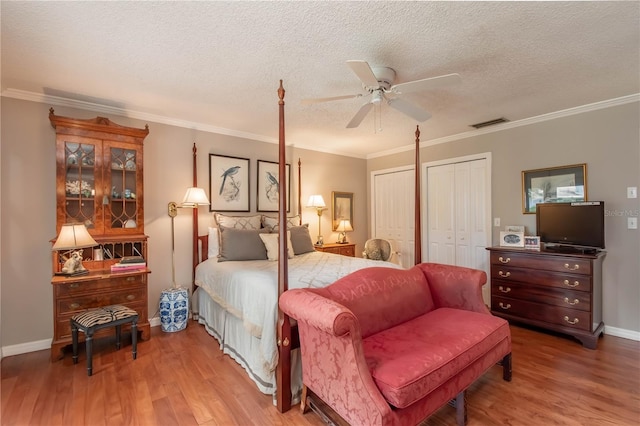 bedroom with hardwood / wood-style flooring, ceiling fan, ornamental molding, and a textured ceiling