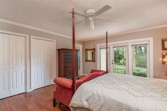 bedroom featuring ceiling fan, crown molding, hardwood / wood-style floors, access to outside, and two closets