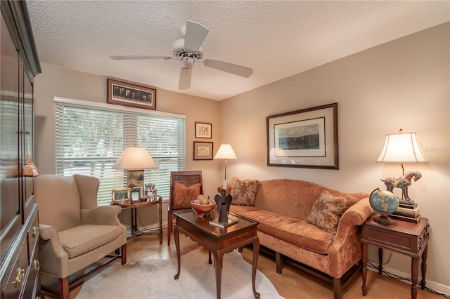 living area with ceiling fan and a textured ceiling