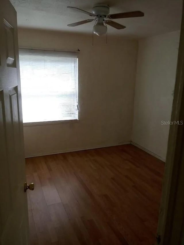 empty room with wood-type flooring and ceiling fan