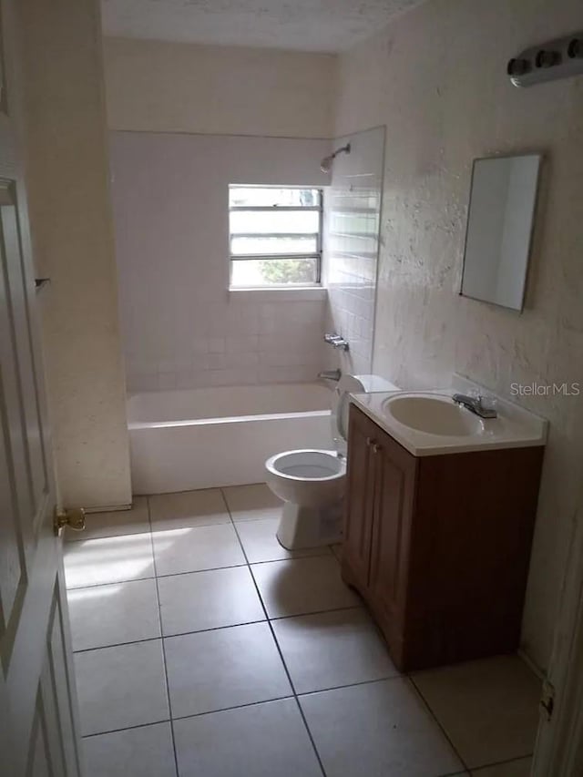 full bathroom featuring tile patterned flooring, vanity, tiled shower / bath combo, and toilet