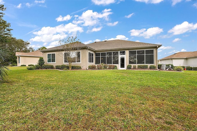 back of house featuring a sunroom and a lawn