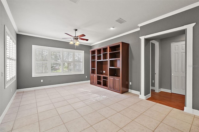 tiled spare room featuring ornamental molding and ceiling fan