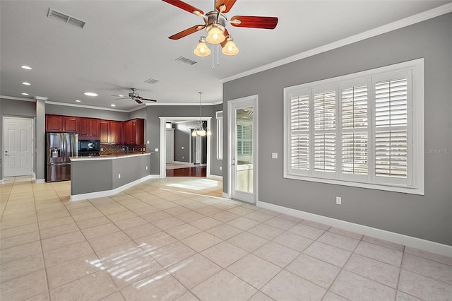 kitchen featuring ceiling fan with notable chandelier, kitchen peninsula, light tile patterned floors, crown molding, and stainless steel fridge