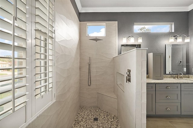 bathroom featuring a wealth of natural light, a tile shower, and ornamental molding