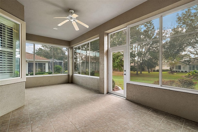 unfurnished sunroom with ceiling fan