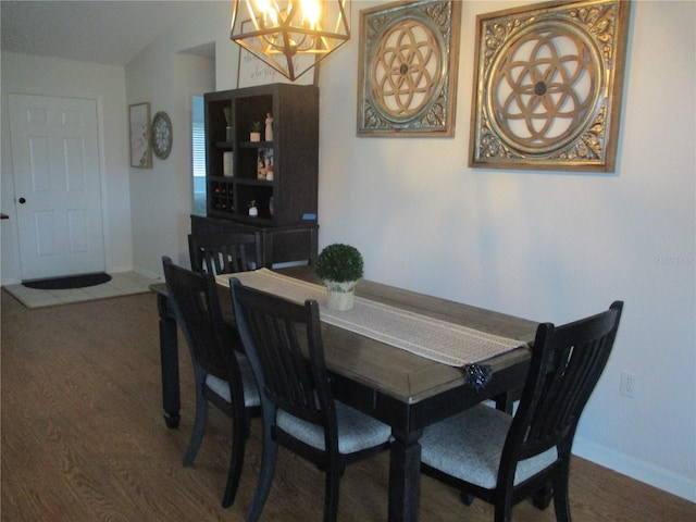 dining space featuring dark hardwood / wood-style flooring and an inviting chandelier