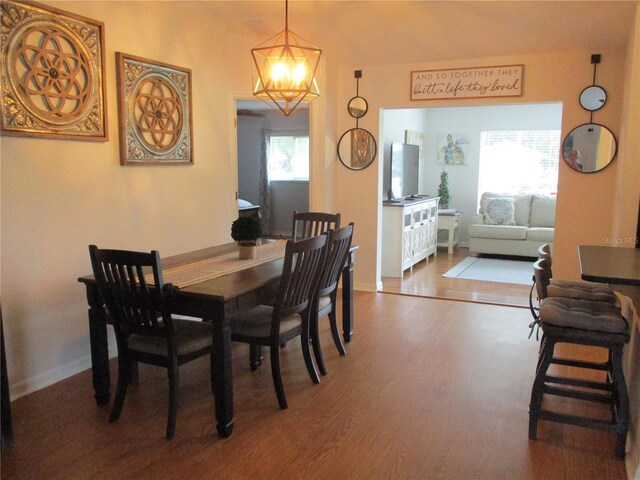 dining area featuring wood-type flooring and a chandelier