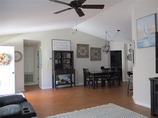 living room with ceiling fan, dark wood-type flooring, and vaulted ceiling