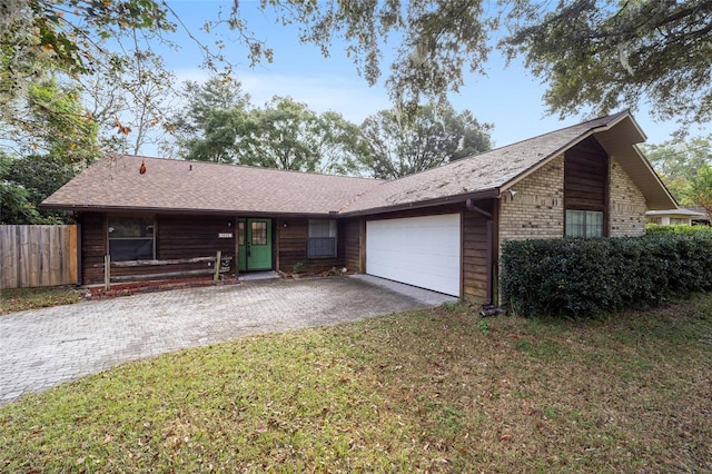 ranch-style home featuring a front lawn and a garage