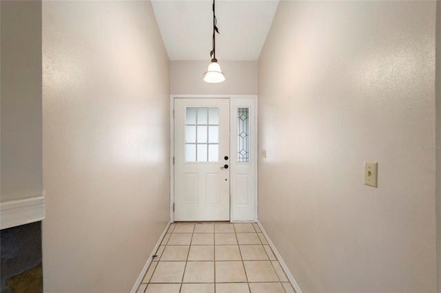 entryway with light tile patterned floors and vaulted ceiling