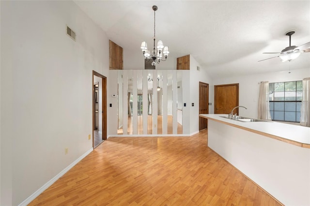 interior space with high vaulted ceiling, sink, ceiling fan with notable chandelier, and light hardwood / wood-style flooring