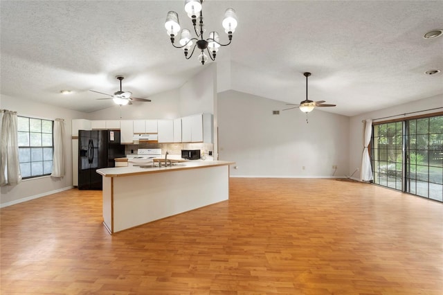 kitchen with white cabinets, a wealth of natural light, black appliances, and light hardwood / wood-style floors